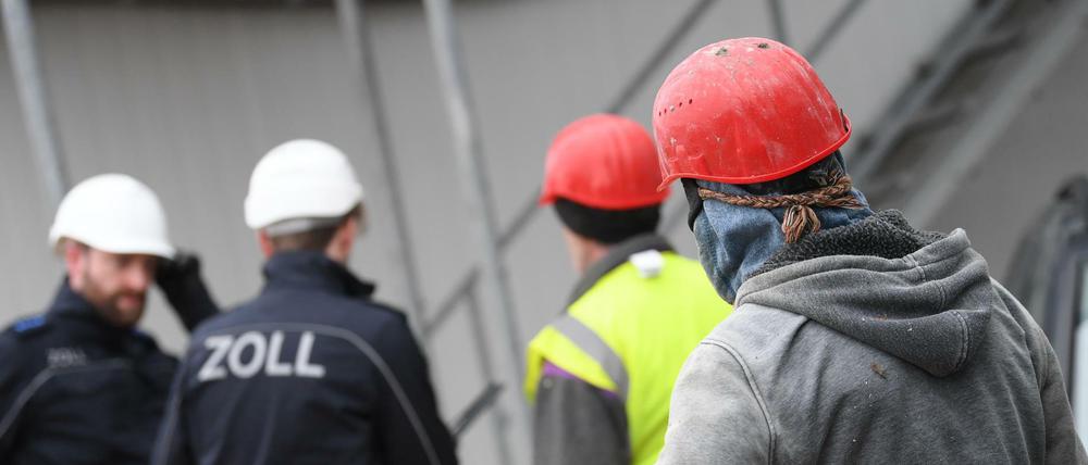 Schwarzarbeit oder zu wenig gezahlt? Zollbeamte kontrollieren eine Baustelle.