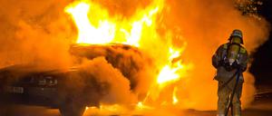 Feuerwehrleute löschen ein brennendes Auto (Archivbild). 