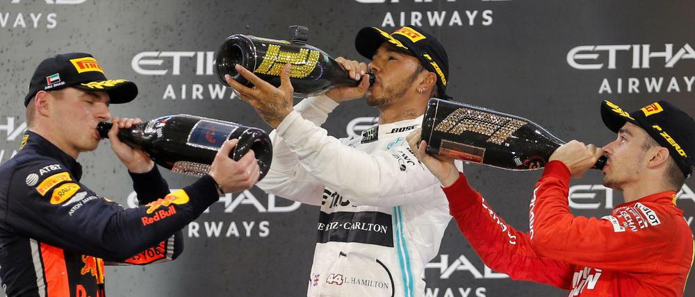 Prost! Lewis Hamilton (Mitte), Max Verstappen (links) und Charles Leclerc (rechts) feiern eine gelungene Formel-1-Saison.
