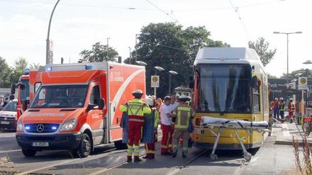 12.06.2018, Berlin: Einsatzkräfte der Feuerwehr stehen neben einer Straßenbahn.