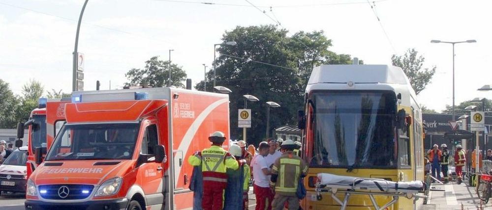 12.06.2018, Berlin: Einsatzkräfte der Feuerwehr stehen neben einer Straßenbahn.