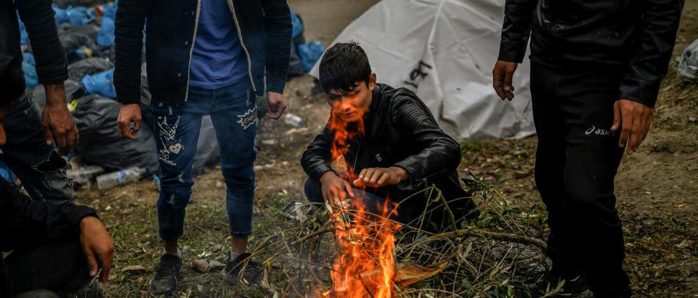 Migranten versuchen sich an einem kleinen Feuer in einem Zwischenlager neben dem Lager Moria auf der Insel Lesbos aufzuwärmen.
