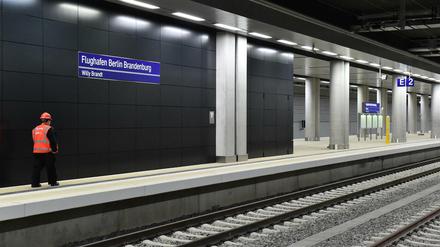 Ein Sicherheitsmitarbeiter läuft durch den Bahnhof des Flughafens Berlin Brandenburg (BER).