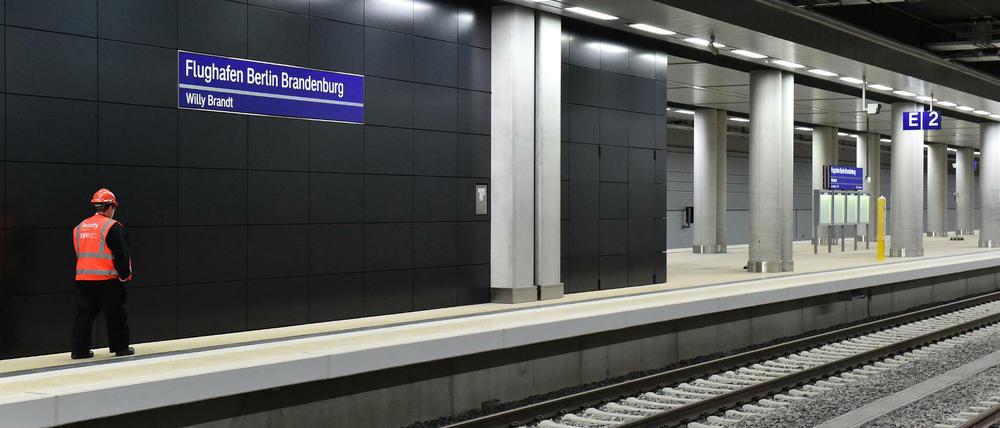 Ein Sicherheitsmitarbeiter läuft durch den Bahnhof des Flughafens Berlin Brandenburg (BER).