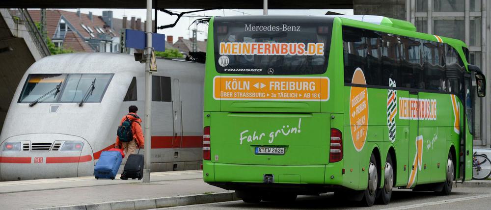 Konkurrenten Seit an Seit. Ein Fernbus und ein ICE am Bahnhof in Freiburg.