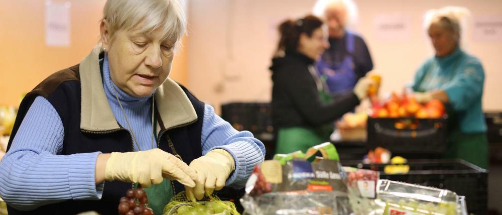 Mitarbeiterin Ute Rucks sortiert in der Lagerhalle der Rostocker Tafel Weintrauben. Mecklenburg-Vorpommerns Tafeln für Bedürftige sind an ihrer Kapazitätsgrenze angelangt. Durchschnittlich werden rund 2.300 Menschen durch die Tafel in Rostock unterstützt.