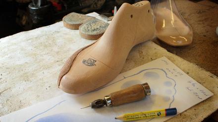 Orthopädie-Schuhmacher, hier mit Leisten , Ahle , Bleistift .  