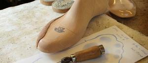 Orthopädie-Schuhmacher, hier mit Leisten , Ahle , Bleistift .  