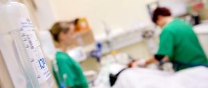 Medizinisches Personal versorgt in einem Krankenhaus einen Patienten.