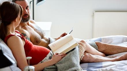 Ein Paar liegt gemeinsam im Bett.