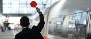 Ein Zugbegleiter gibt am Hauptbahnhof in München das Signal zur Abfahrt.