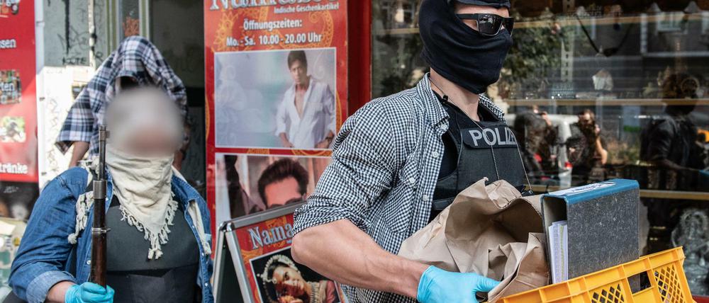 Beamte der Polizei bringen sichergestellte Gegenstände nach einer Razzia in einer Wohnung eines Mitglieds einer arabischen Großfamilie zu ihrem Auto. 