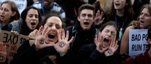Klima-Aktivisten, die sich ein "wachsames" Auge auf die Handfläche gemalt haben, protestieren in Madrid.