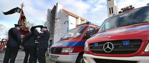 Angehörige der Feuerwehr stehen vor Beginn der Trauerfeier für einen getöteten Feuerwehrmann vor der Pfarrkirche St. Ägidius in Neusäß.