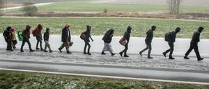 Flüchtlinge gehen an der deutsch-österreichischen Grenze während eines Schneeschauers nach Deutschland. 