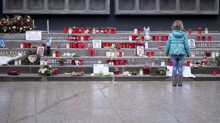 Ein Mädchen betrachtet Kerzen, Blumen und Andenken an der Gedenkstätte auf dem Breitscheidplatz. (Archivbild)