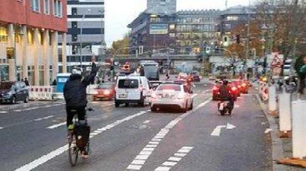 Radfahrer zeigt an, dass Autofahrer auf seiner Spur fahren.