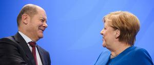 Olaf Scholz (SPD) und Angela Merkel (CDU) geben sich die Hand.