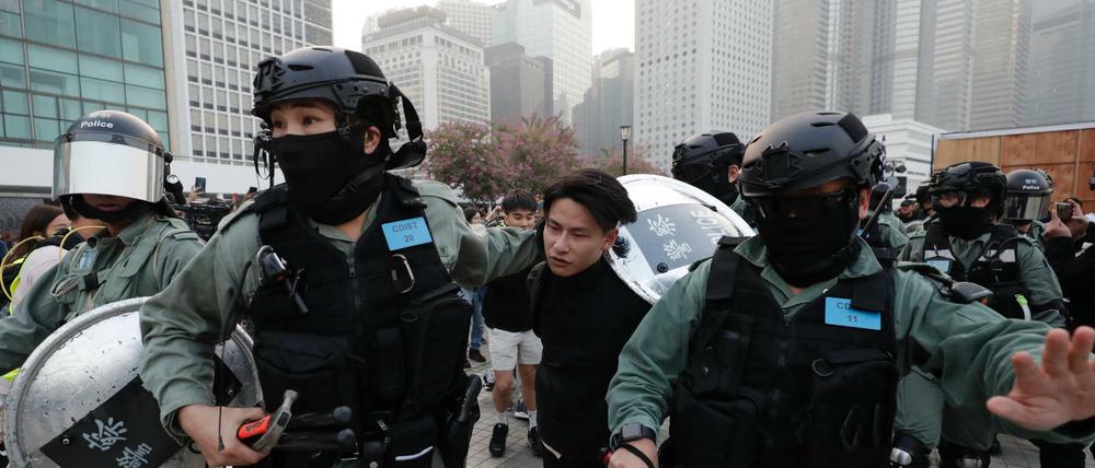 Hongkonger Polizisten nehmen einen Demonstranten fest.