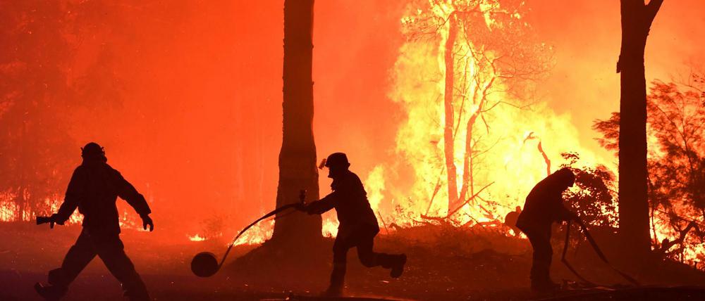 Freiwillige und Feuerwehrleute löschen einen Brand.