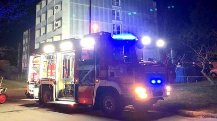 Ein Feuerwehrfahrzeug steht vor dem Mehrfamilienhaus in Werder an der Havel, in dem es in der Nacht zu Heiligabend gebrannt hat.