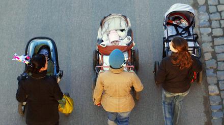 Drei junge Mütter schieben ihre Babys im Kinderwagen bei einem gemeinsamen Spaziergang in Frankfurt am Main. (Archivbild)