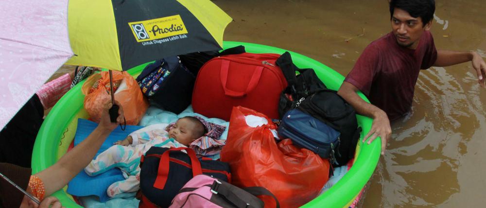 Hochwasser im Raum Jakarta: Ein Baby wird in Sicherheit gebracht.