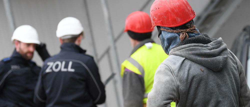 Zollbeamte kontrollieren Bauarbeiter