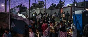 Migranten verlassen das Lager Moria durch ein Loch im Zaun auf der Insel Lesbos.