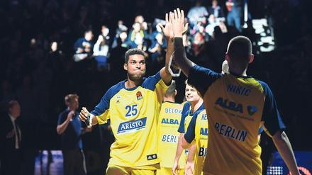 Alba Berlins Basketballer Kenneth Ogbe und seine Teamkollegen zelebrieren das High Five beim Einlaufen.