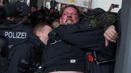 Polizisten nehmen einen Teilnehmer der rechten Kundgebung gegen den WDR wegen Widerstand in Gewahrsam.