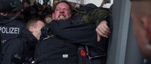 Polizisten nehmen einen Teilnehmer der rechten Kundgebung gegen den WDR wegen Widerstand in Gewahrsam.