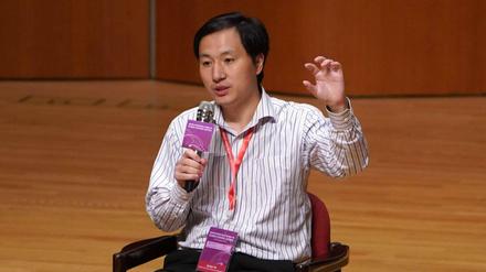 Bei einer Konferenz spricht He Jiankui in ein Mikrofon und gestikuliert.