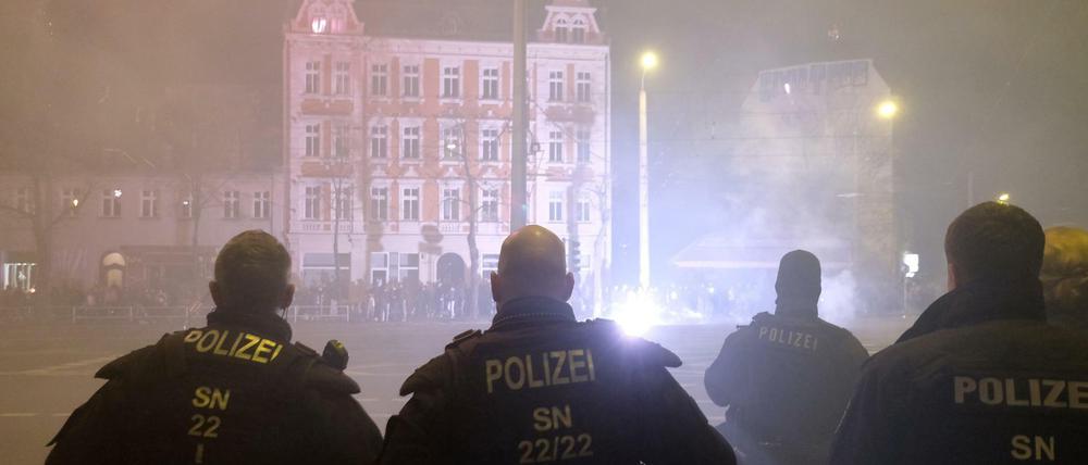 Polizisten stehen in der Silvesternacht an einer Kreuzung im Stadtteil Connewitz.