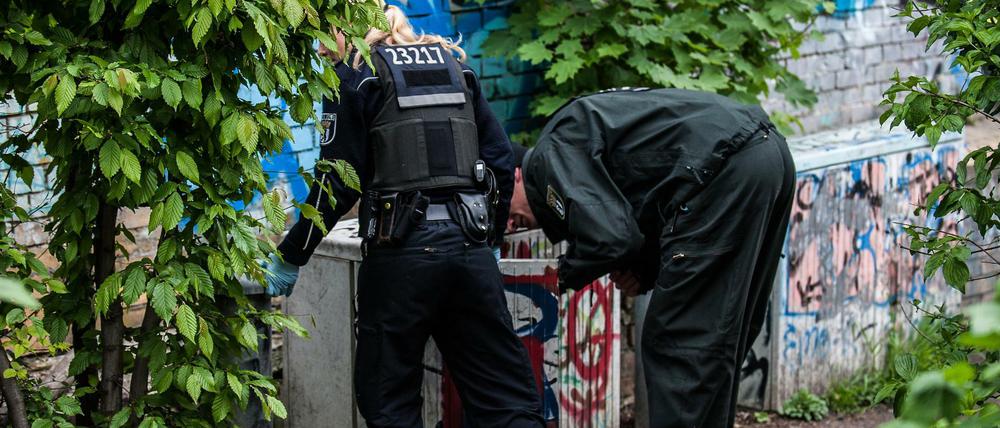 Polizeibeamte suchen im Görlitzer Park nach versteckten Drogen.
