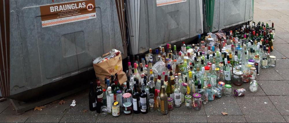 Flaschen, die vor und auf Altglascontainern aufgereiht wurden, weil diese überfüllt sind.
