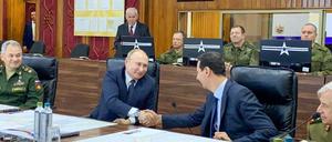 Putin (l) und Assad schütteln sich am Sitz der russischen Streitkräfte in Damaskus die Hände.