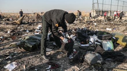 Detailarbeit: Ein Mann durchsucht die Trümmer an der Absturzstelle bei Teheran.