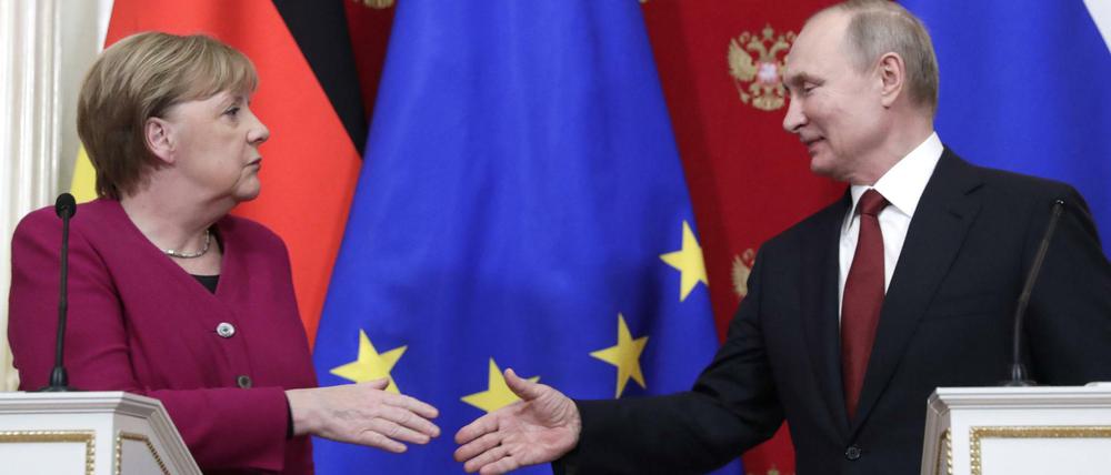 Angela Merkel und Russlands Präsident Wladimir Putin reichen sich die Hände.
