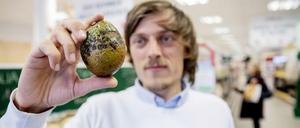 Sirplus-Gründer Raphael Fellmer hält eine fleckige Avocado.
