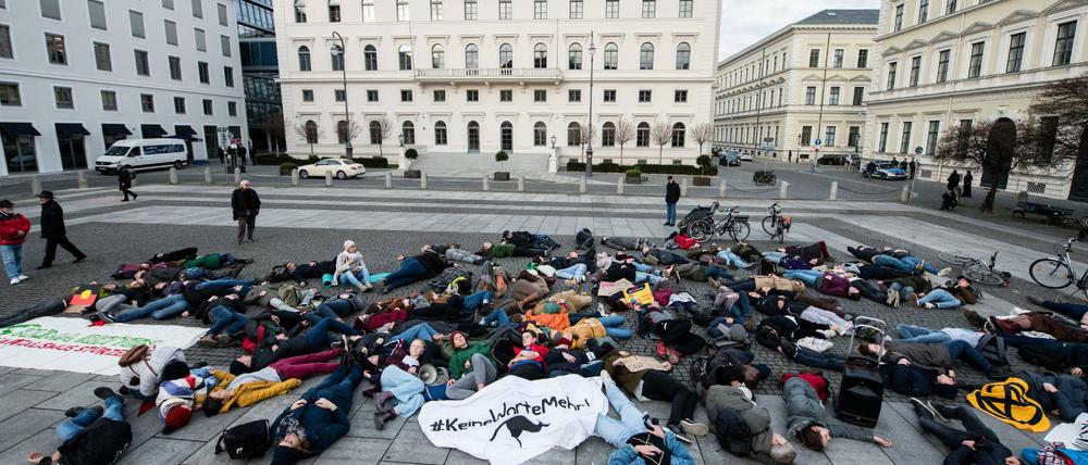Demonstrationsteilnehmer liegen während einer Protestaktion von Fridays for Future vor der Siemens Zentrale auf dem Wittelsbacher Platz für ein "Die-In" regungslos am Boden. Die Demonstrierenden hatten sich als Reaktion auf die Siemens-Entscheidung zu der Technik-Lieferung für ein umstrittenes Kohlebergwerk-Projekt in Australien zu Kundgebungen an verschiedenen Standorten in Deutschland verabredet.