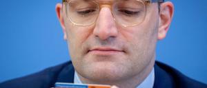 Jens Spahn (CDU), Bundesminister für Gesundheit, schaut während der Präsentation der neuen Organspende-Regeln auf einen Organspendeausweis.