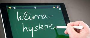 Das Unwort des Jahres wird bei einer Pressekonferenz auf ein Tablet geschrieben.