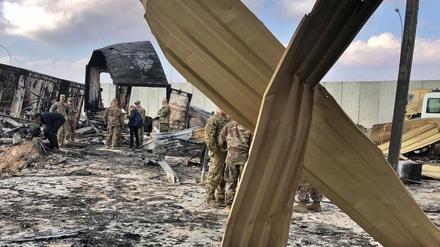US-Soldaten und Journalisten inspizieren die Trümmer auf dem US-Stützpunkt Al Asad. 