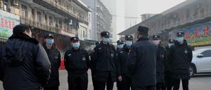 Wachleute stehen vor dem geschlossenen Fischmarkt in Wuhan. Hier war die Krankheit ausgebrochen.