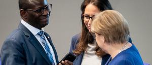 Bundeskanzlerin Angela Merkel (CDU) unterhält sich im Bundestag mit Karamba Diaby und Yasmin Fahimi (beide SPD). 