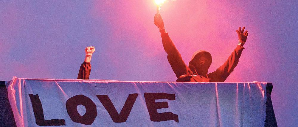 Anwohner der Rigaer Straße protestieren mit Bengalischen Feuern.