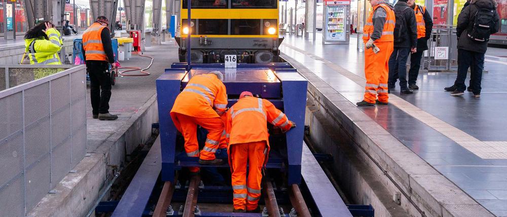 Mitarbeiter der Deutschen Bahn AG reparieren den beschädigten Prellbock am Frankfurter Hauptbahnhof. 
