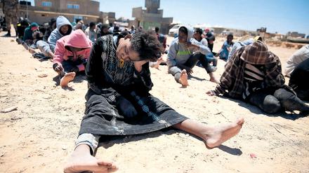 Zurück in der Hölle: Eine Gruppe von Geflüchteten, die die libysche Küstenwache im Meer aufgriff, nach der Landung an einem Strand bei Tripolis
