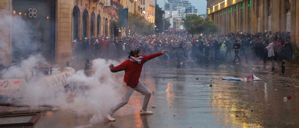 Ein Demonstrant wirft bei Protesten in Beirut einen Tränengaskanister. 